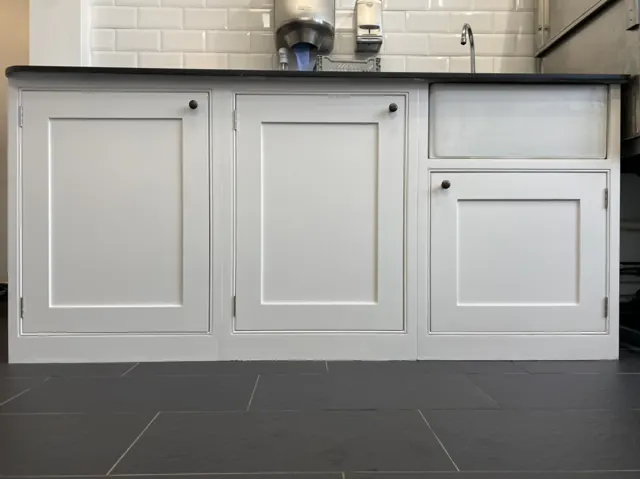 Kitchen base units hand-painted white under a metro-tiled splashback