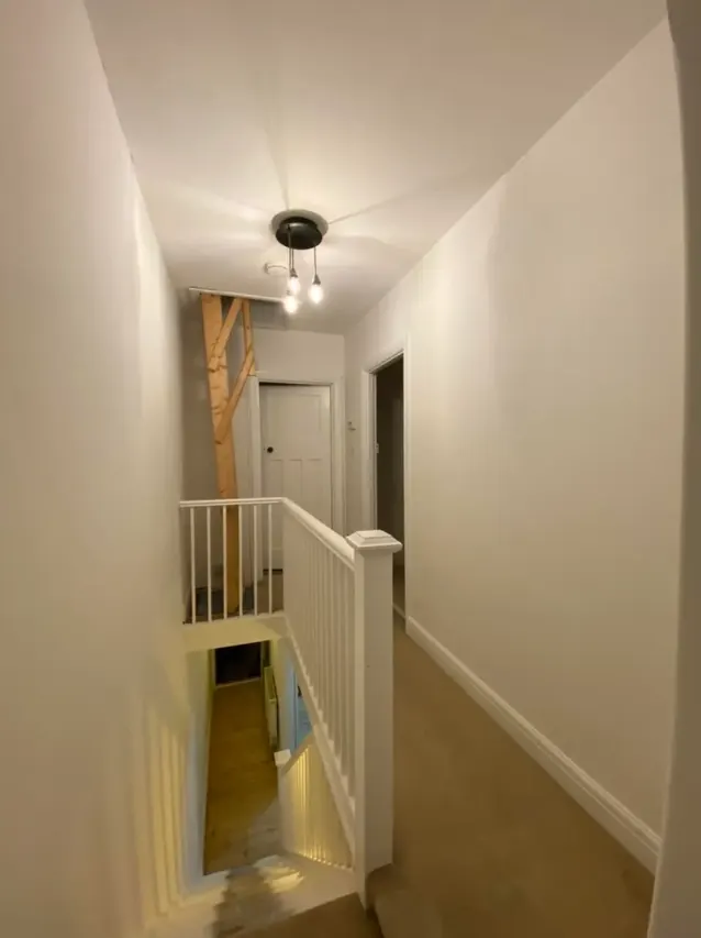 Bright redecorated landing with white walls and a painted banister